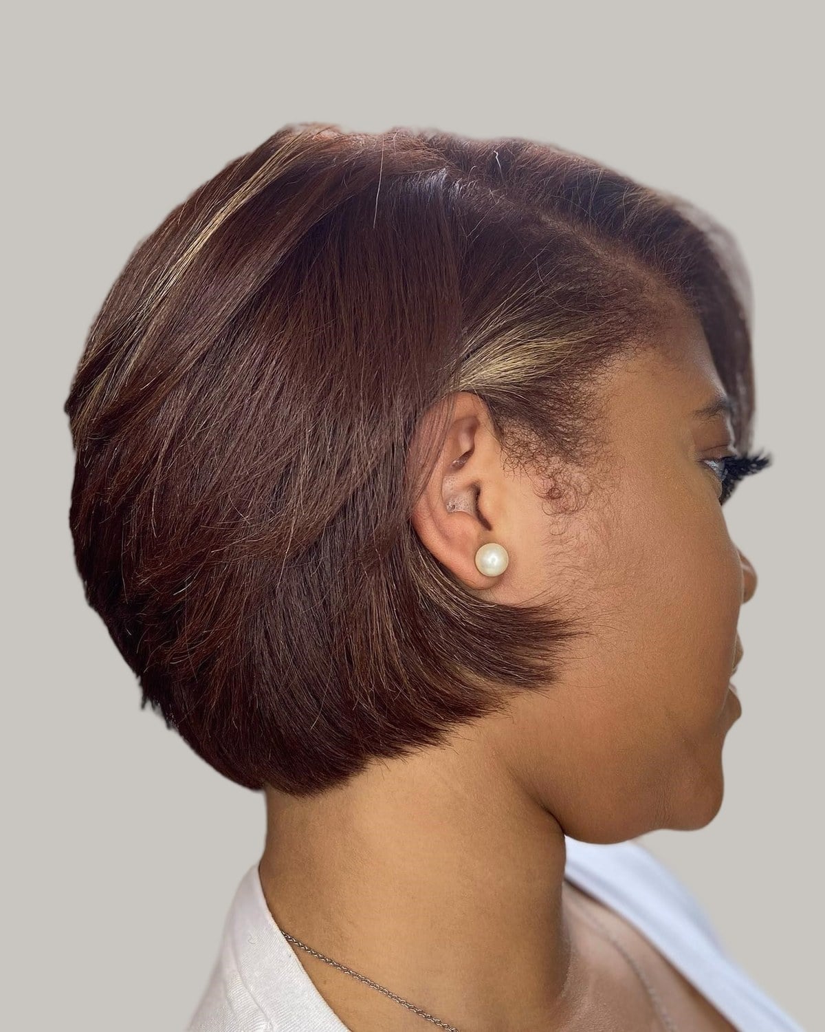 Woman with a short burgundy-brown bob, seen in profile