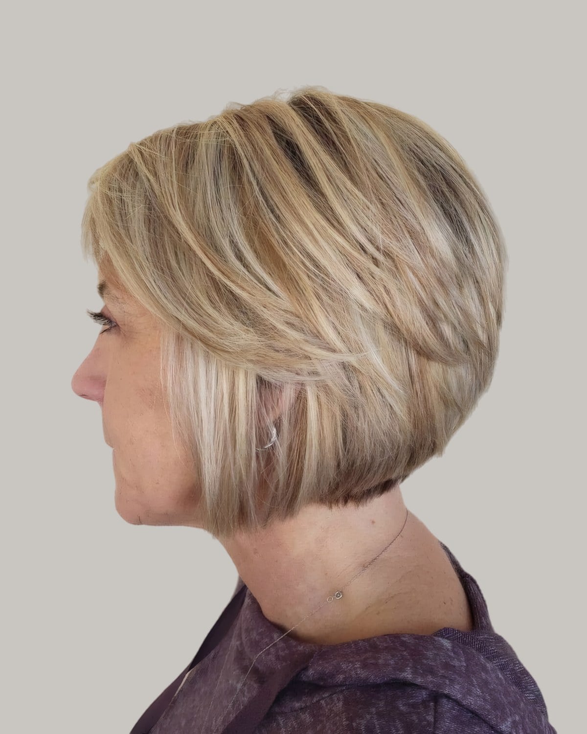 Woman with a blonde chin-length bob, seen in profile