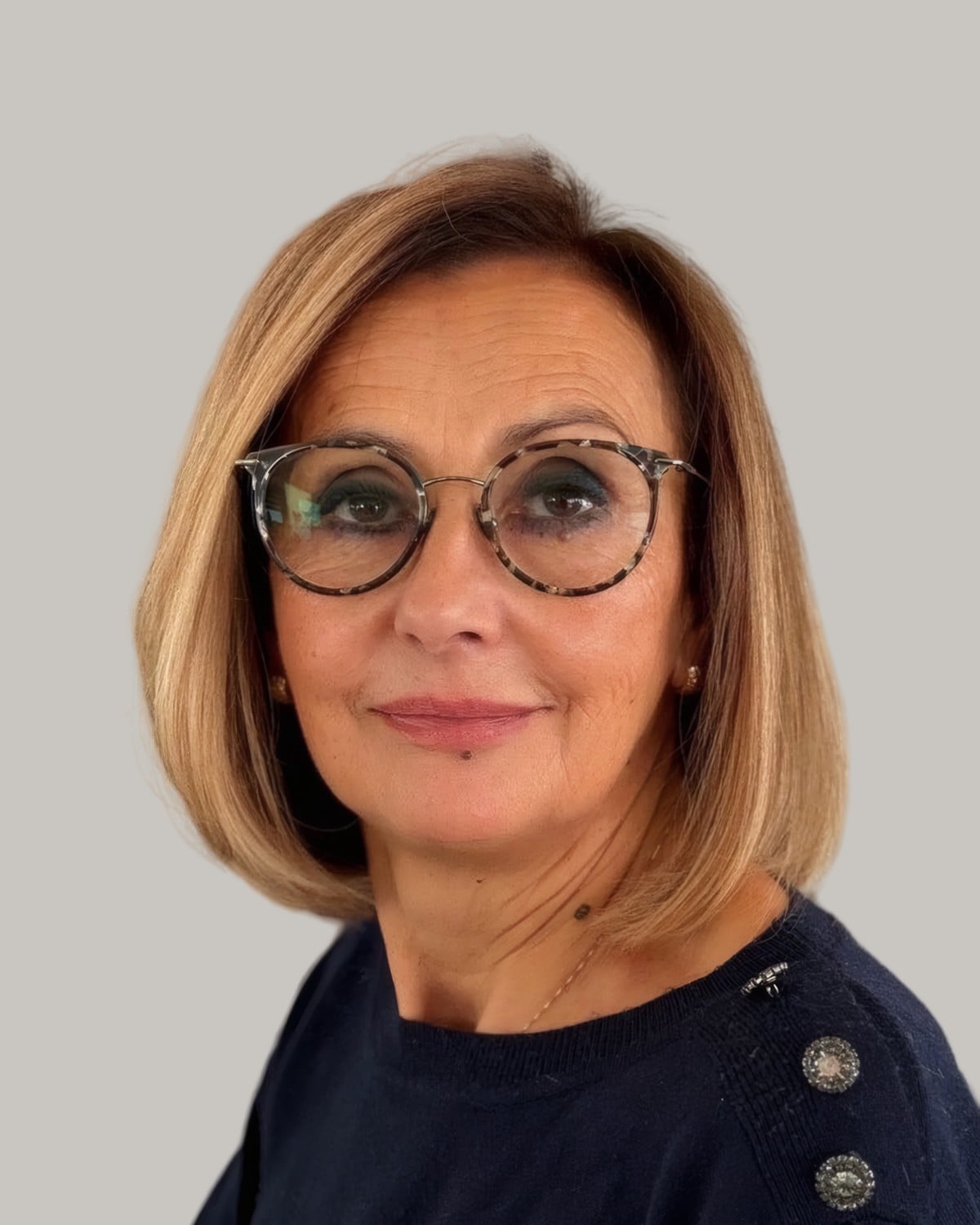 Woman with a honey-blonde bob and round tortoiseshell glasses