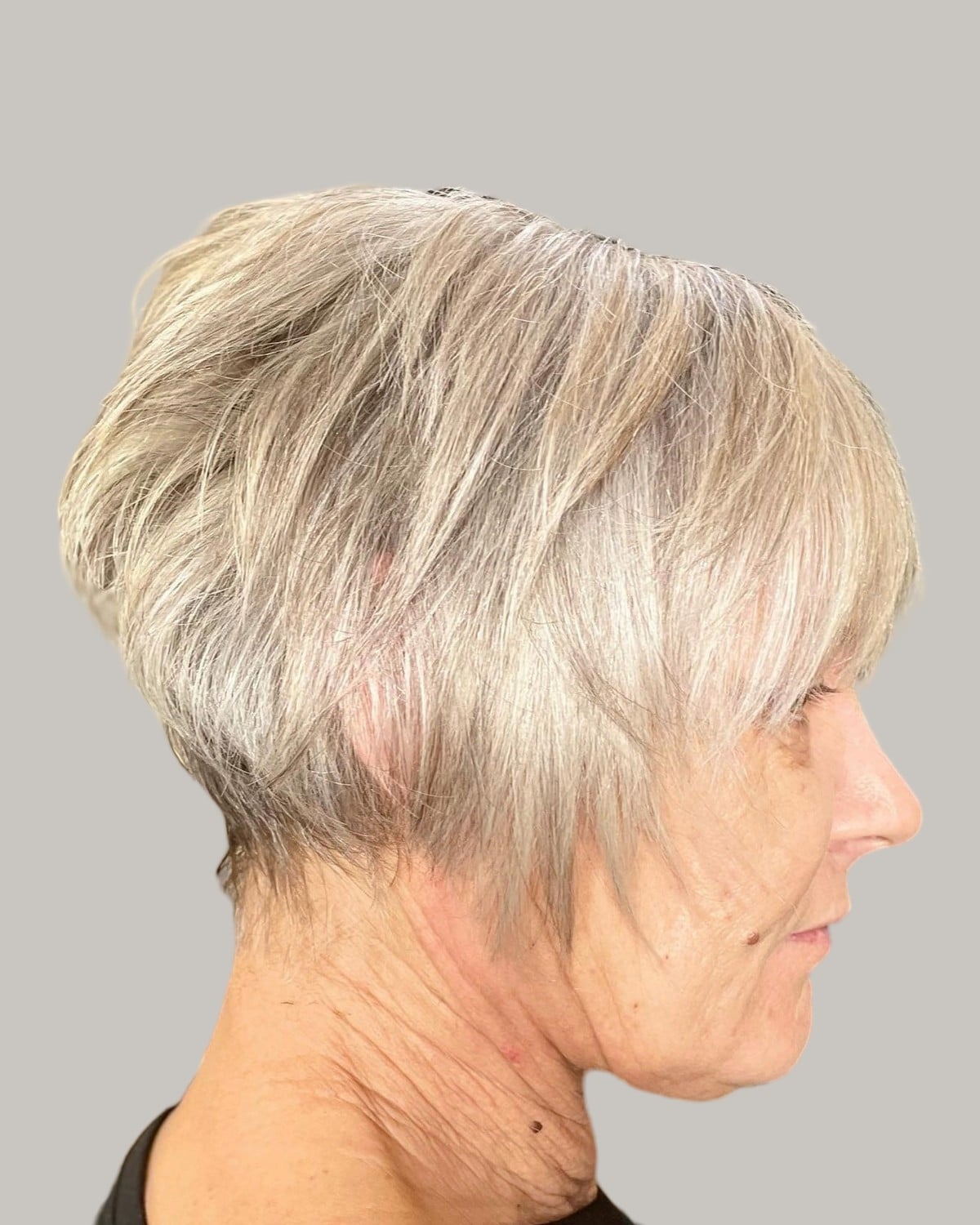 Woman with a long ash-blonde pixie, seen in profile