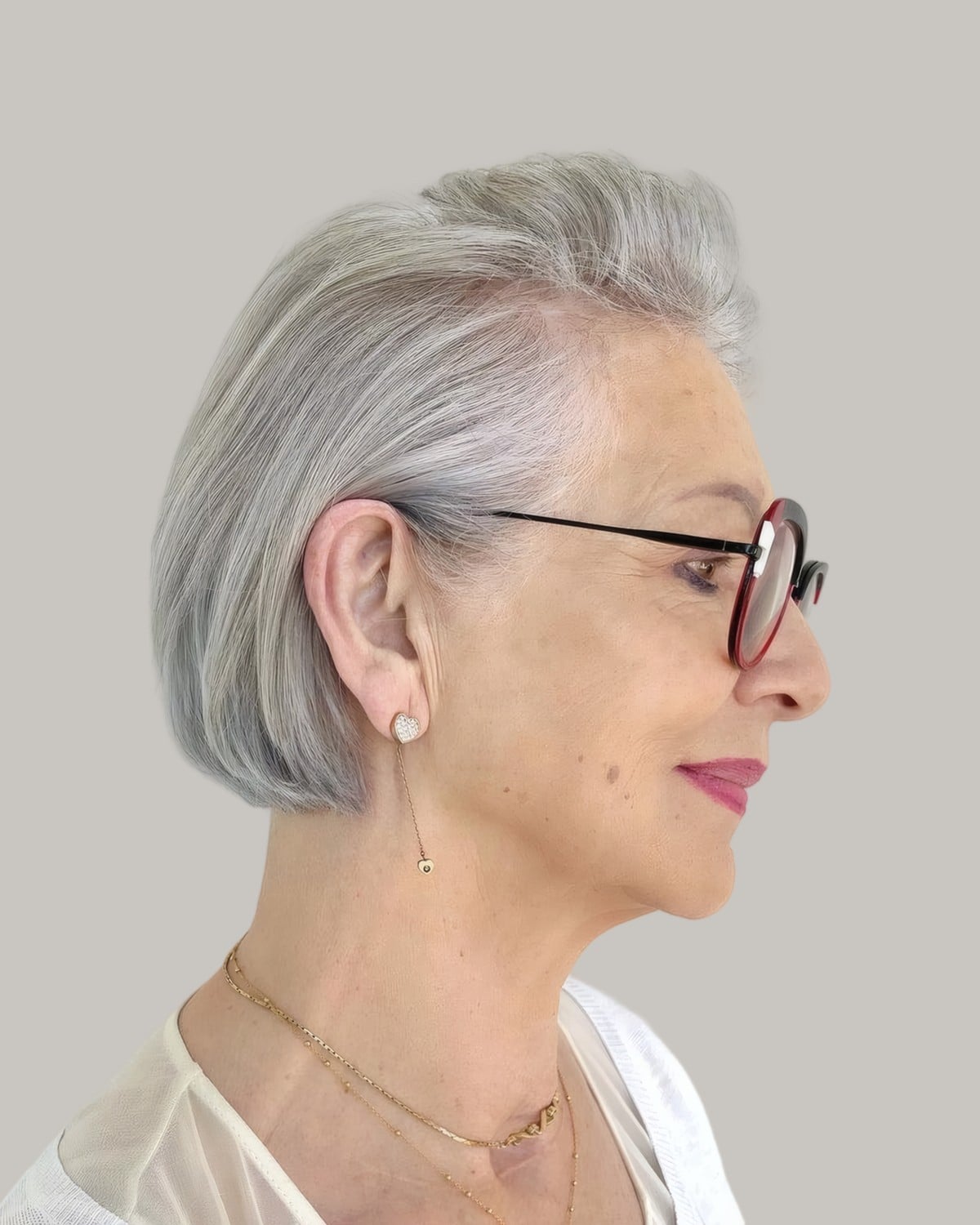 Woman with a silver bob and thin tortoiseshell glasses, in profile