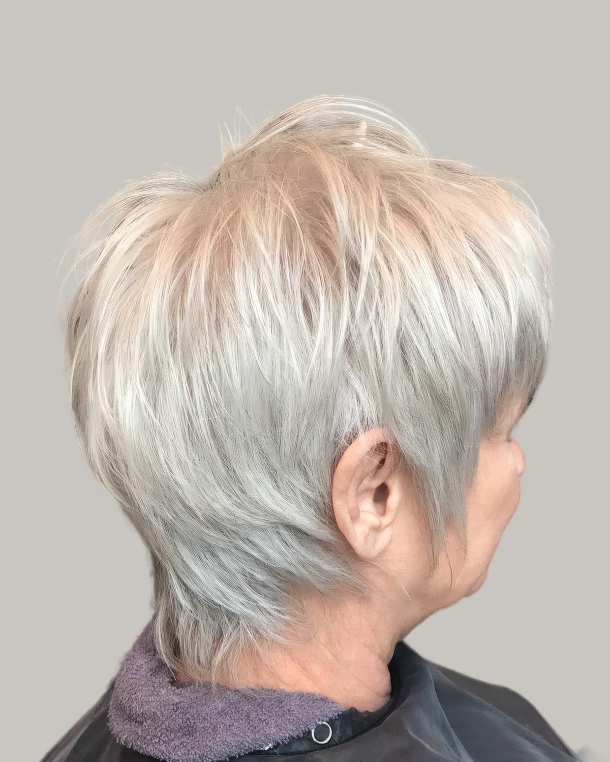 Woman with a pale blonde-white pixie, seen from behind