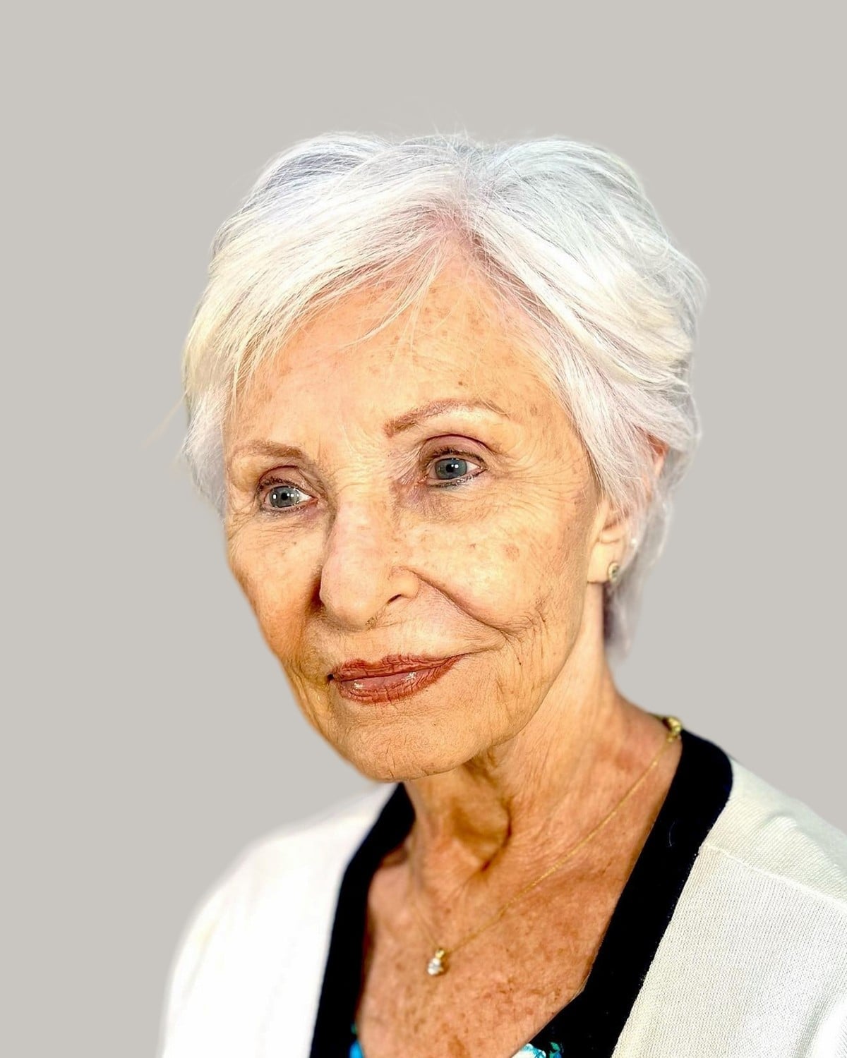 Woman with a soft white pixie, in three-quarter view