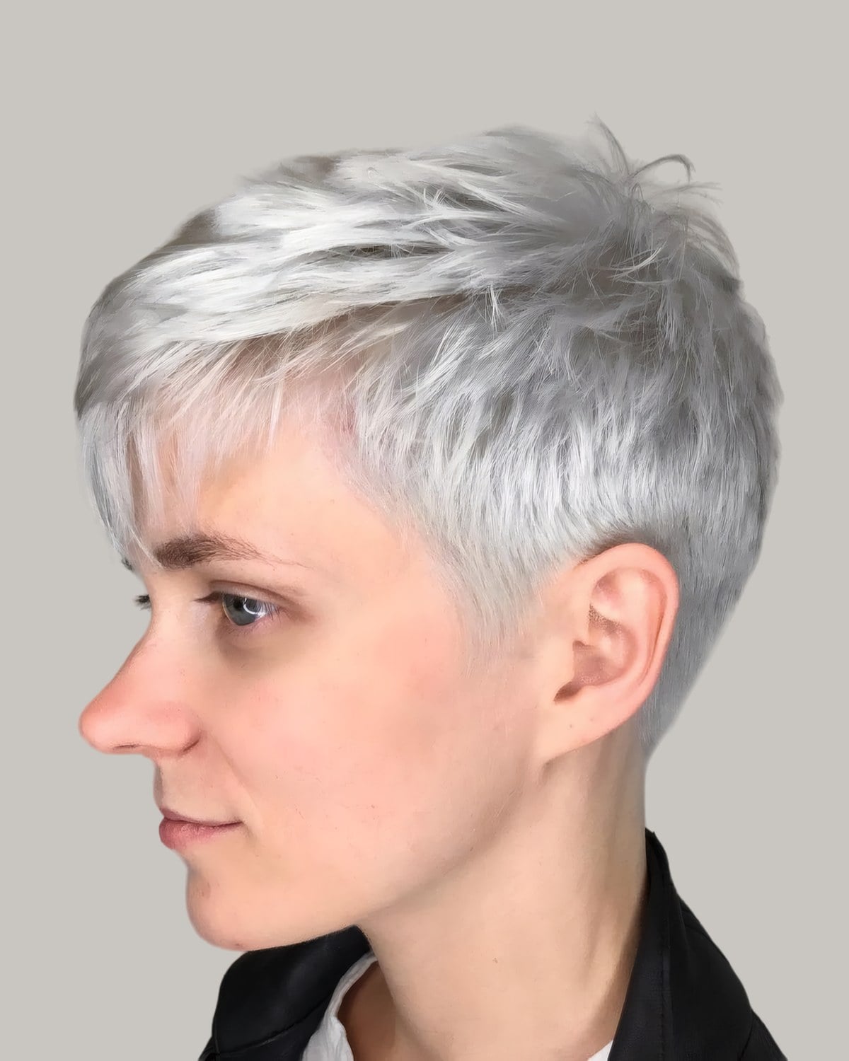 Woman with a silver pixie in profile, the fringe swept down