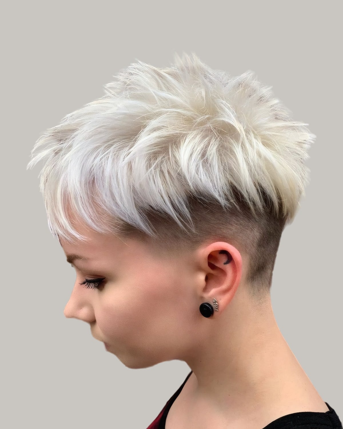 Woman with a platinum undercut pixie, looking down