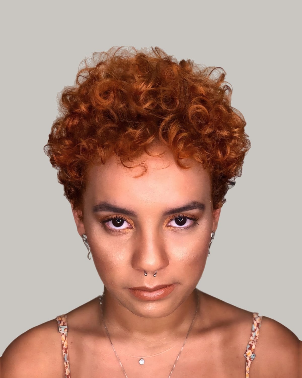 Woman with short copper coils, facing the camera