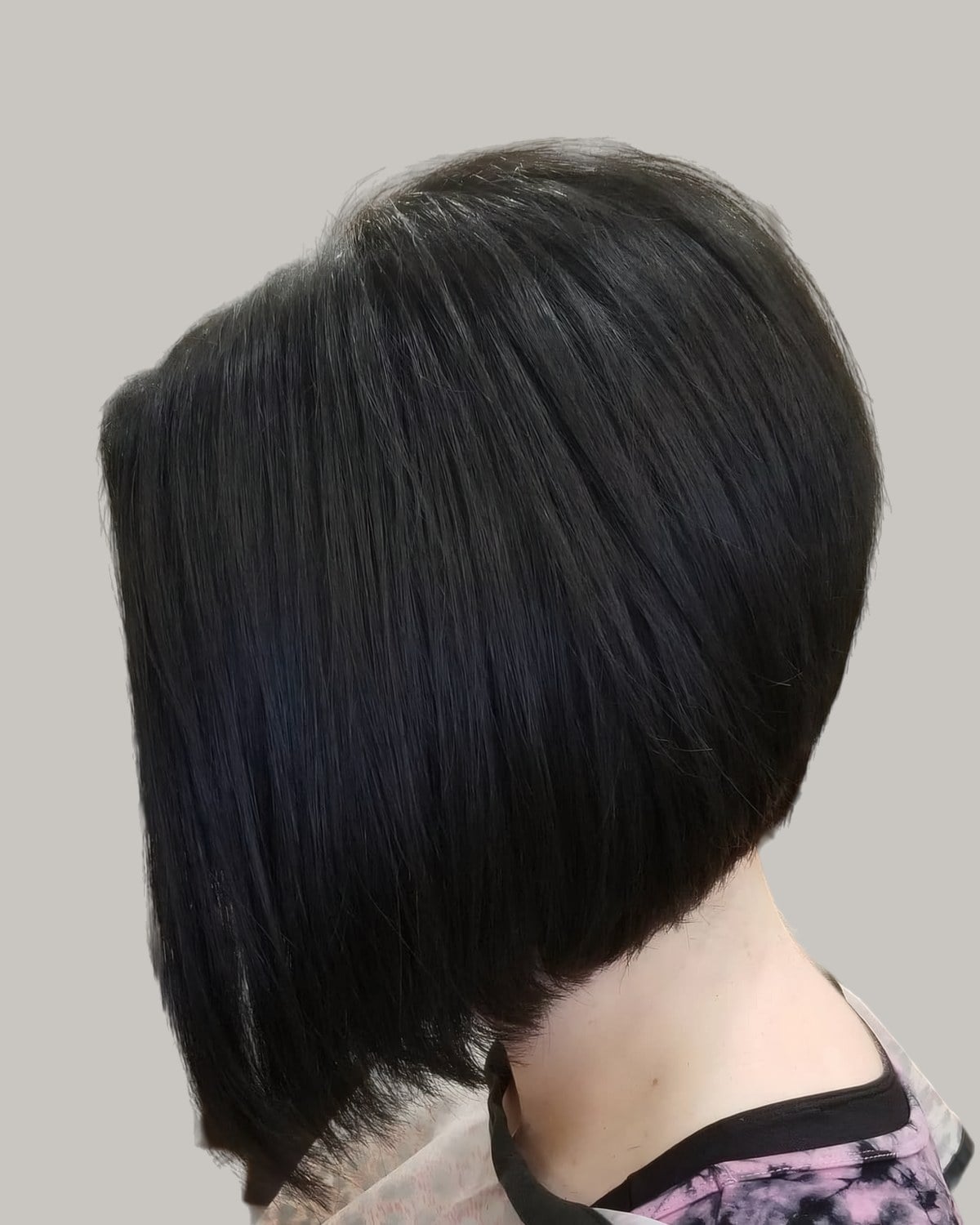 Woman with a sleek black A-line bob, seen from the side
