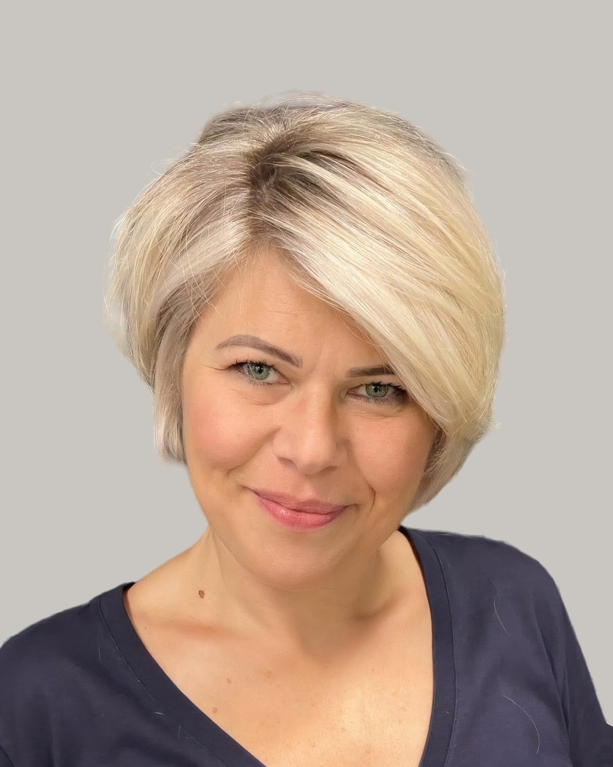 Smiling woman with a soft blonde bob and a side-swept fringe
