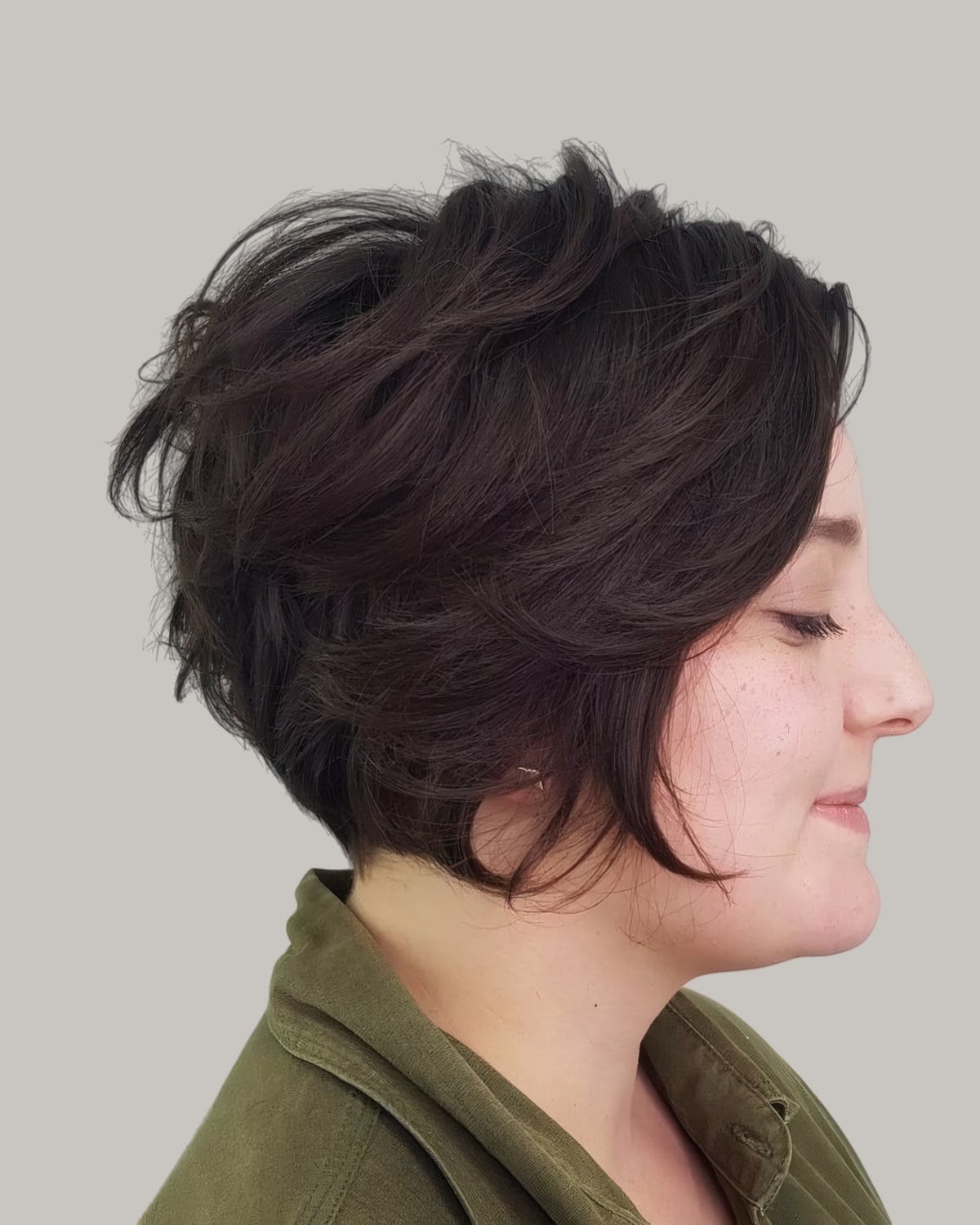 Woman with a dark wedge cut, seen from the side