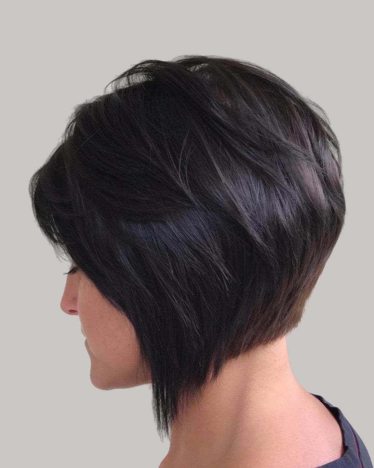Woman with a dark stacked bob seen from behind at an angle