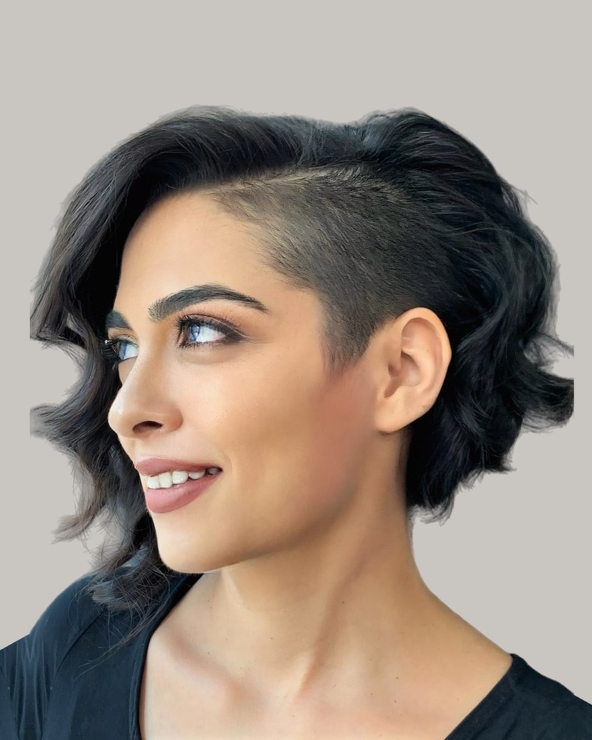 Smiling woman with a wavy dark bob and a shaved side