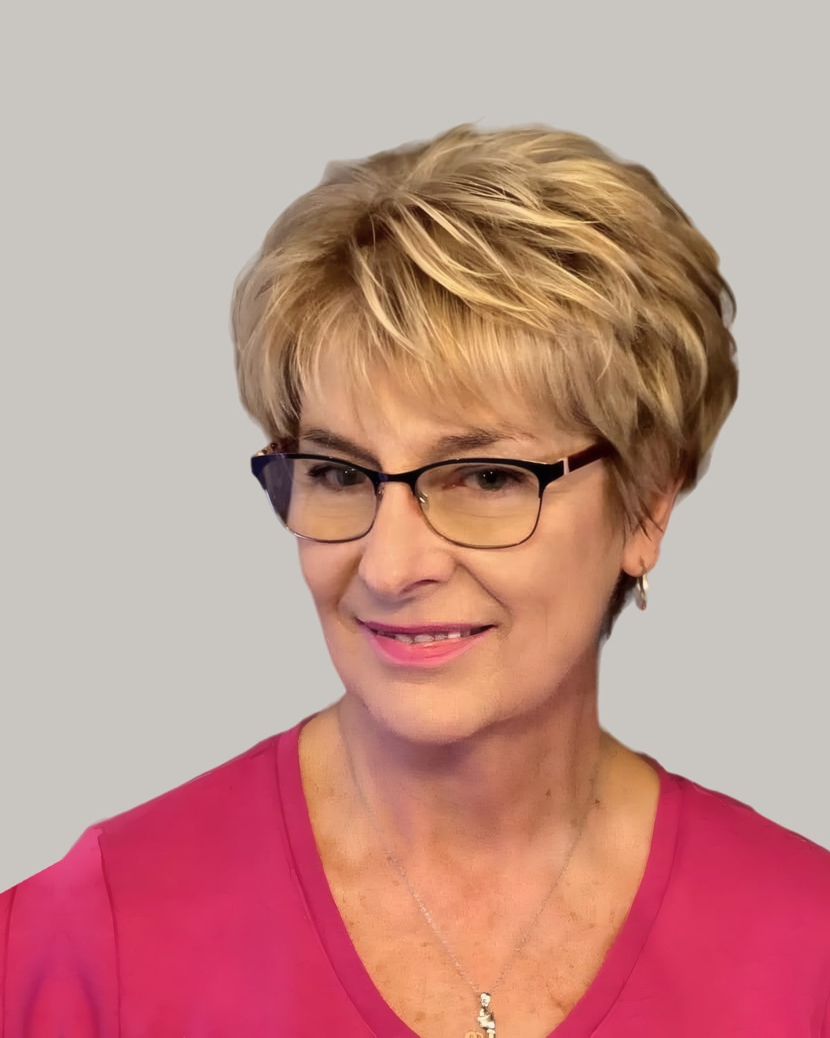Smiling woman with a golden-blonde layered pixie and glasses
