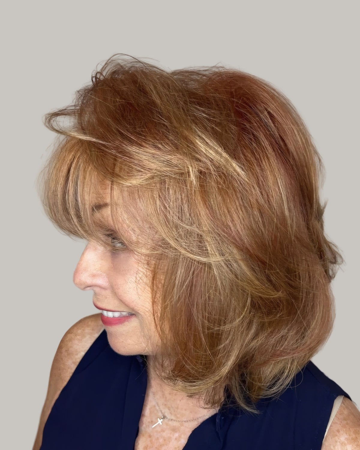 Woman with copper and blonde layered hair, seen in profile