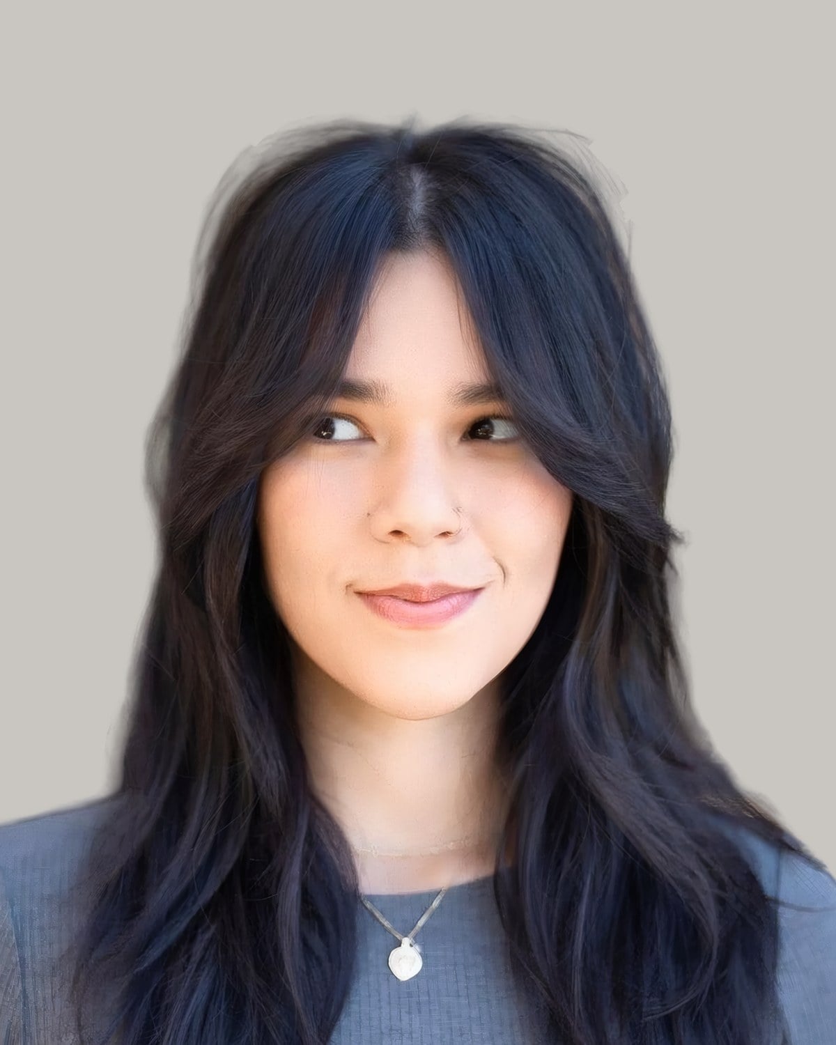 Woman with black hair past the shoulders, long curtain bangs and layers