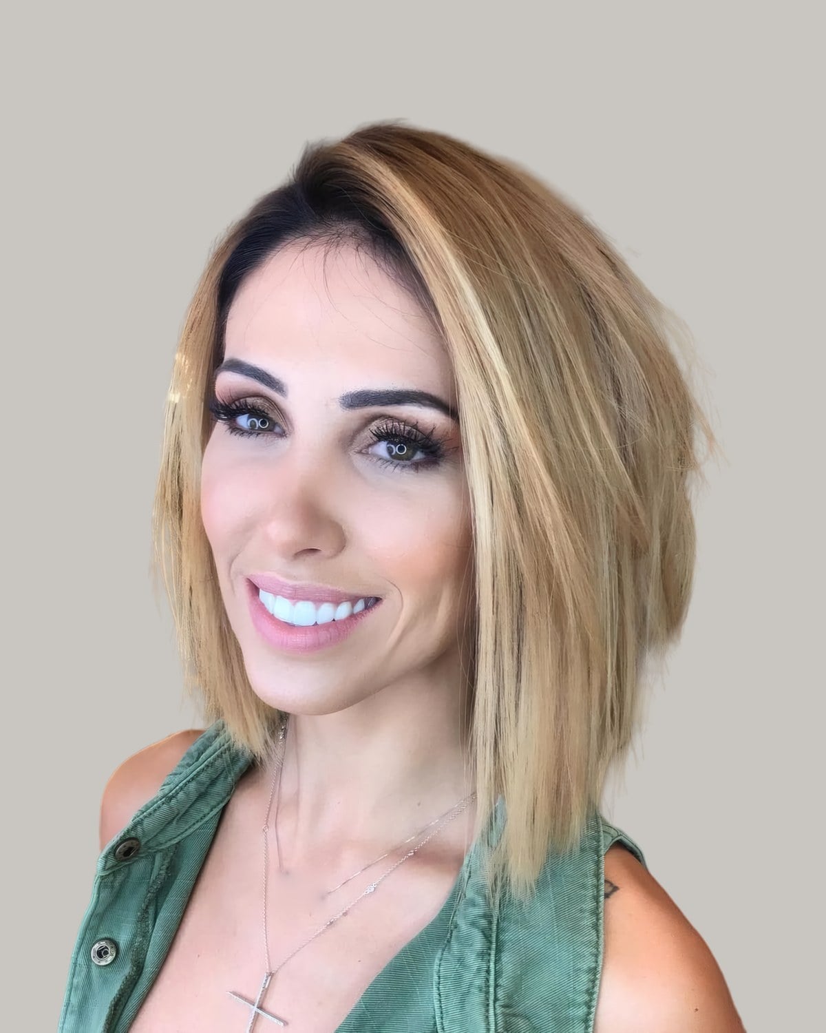 Smiling woman with a blonde razored lob, longer at the front, side part