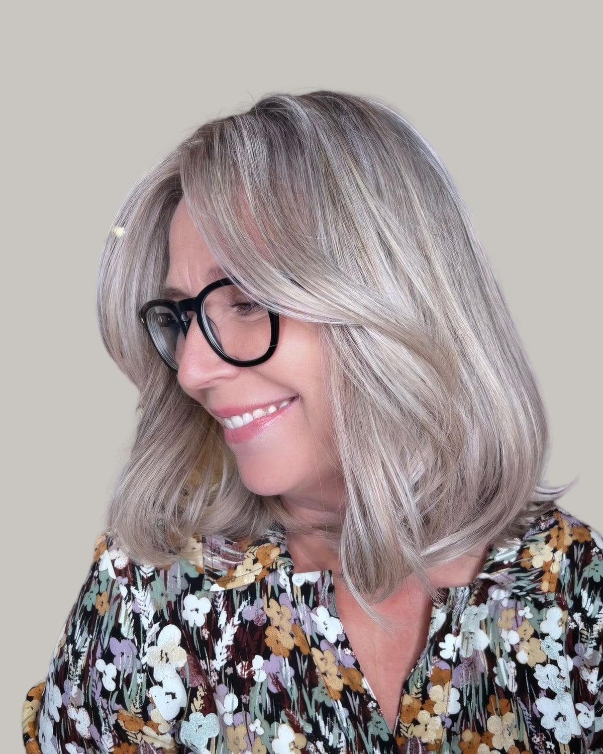 Smiling woman with silver-blonde hair past the shoulders and glasses